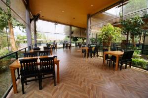 a restaurant with tables and chairs and large windows at Kwai Tara Riverside Villas in Sai Yok