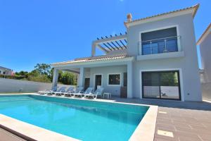 a villa with a swimming pool and a house at Villa Goncinha - Piscina in Loulé