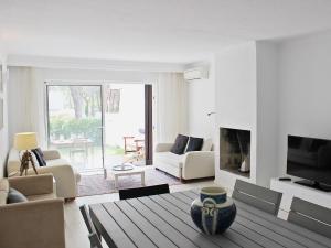 a living room with a couch and a fireplace at Villa Vale Garrão in Almancil