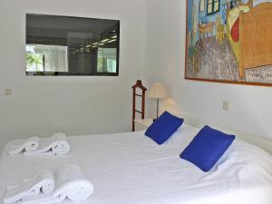 a white bed with blue pillows and towels on it at Villa Vale Garrão in Almancil