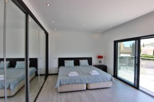 a bedroom with two beds and large glass windows at Villa Goncinha - Piscina in Loulé +17 photos