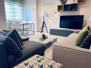 a living room with two couches and a flat screen tv at Roma Suite Trastevere Railway Station in Rome