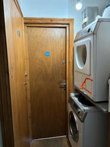 uma porta de madeira numa cozinha ao lado de uma máquina de lavar roupa em Stay in Islington/Arsenal em Londres