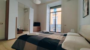 a bedroom with a large bed and a large window at DUHOME apartment in the heart of Catania in Catania