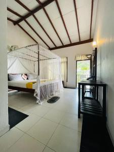 a bedroom with a bed with a mosquito net at Rainbow Surf Beach in Koggala