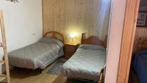 ein kleines Zimmer mit 2 Betten und einer Lampe in der Unterkunft Casa Casteller 1-4 huéspedes in Arfa