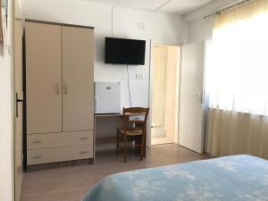 a bedroom with a bed and a desk and a tv at Summer rooms Baška 2 in Baška