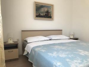 a bedroom with a bed and a painting on the wall at Summer rooms Baška 2 in Baška