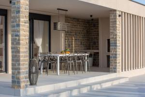 a patio with a table and chairs on a building at Villa Rose Nin ZadarVillas in Nin