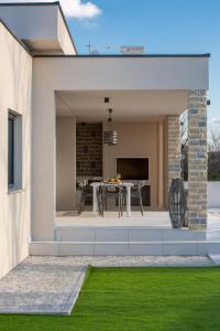 an extension of a house with a patio and grass at Villa Rose Nin ZadarVillas in Nin