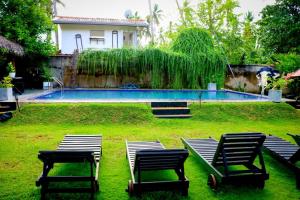 a yard with two chairs and a swimming pool at coco cabana in Bentota