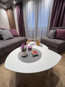 un soggiorno con tavolo bianco e divano di Apartman Nikolina a Kopaonik