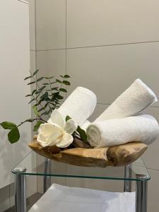 a basket with towels and flowers on a glass table at Ferienwohnungen am Markt - direkt am Historischen Marktplatz in Eschwege