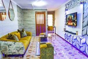 a living room with a yellow couch and a tv at Homes of Ace Executive in Pretoria