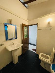 La salle de bains est pourvue d'un lavabo et de toilettes. dans l'établissement Rainbow Surf Beach, à Koggala
