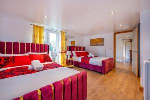 2 camas en una habitación con rojo y blanco en *RE98BL* For your most relaxed & Cosy stay + Free Parking + Free Fast WiFi *, en Farnley