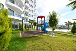 een speeltuin in een tuin voor een gebouw bij Nova 1 room in Alanya