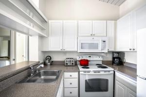 a kitchen with white cabinets and a stove and a sink at Culver City 2BR w Gym Pool nr shops LAX-330 in Los Angeles