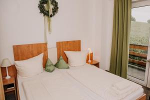 a bedroom with a bed with white sheets and a window at Landhaus Kopenhagen in Kalletal