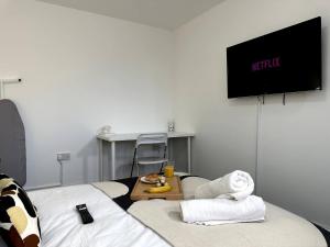 a room with a bed with a television and a table at Chic Birmingham Studio with Natural Light! in Birmingham