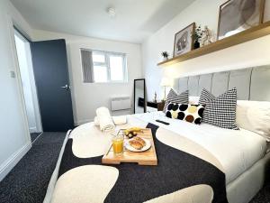 a bedroom with a large bed with a tray of food on it at Chic Birmingham Studio with Natural Light! in Birmingham