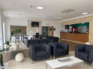 una sala d'attesa con sedie e tavoli blu di Perola Verde Hotel a Birigui