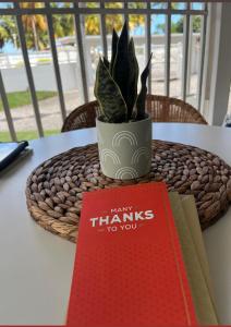 un libro y una maceta en una mesa en Isla Verde frente a la playa y Piscina, Céntrico y Accesible en San Juan