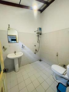 La salle de bains est pourvue d'un lavabo et de toilettes. dans l'établissement Rainbow Surf Beach, à Koggala