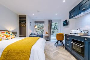 a bedroom with a bed with a yellow bedspread at No.6 - Studio Apartment with Private Terrace in Stony Middleton