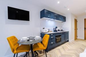 a kitchen with a table and yellow chairs in a room at No.6 - Studio Apartment with Private Terrace in Stony Middleton