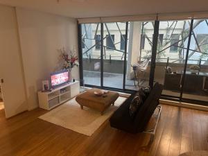 a living room with a couch and a tv at Stylish 1 bedroom best location in Sydney