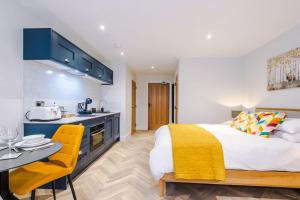 a bedroom with a king sized bed and a kitchen at No.6 - Studio Apartment with Private Terrace in Stony Middleton