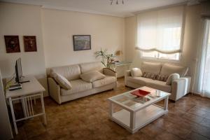 een woonkamer met 2 banken en een salontafel bij Benimar 1 in Cala de Finestrat