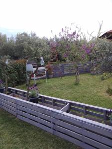 a garden with a wooden fence and some flowers at Agrikia tis Vasilikis in Ormília
