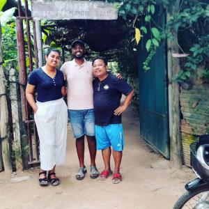 Un groupe de trois personnes debout devant une porte dans l'établissement Sok Phen Homestay, à Siem Reap
