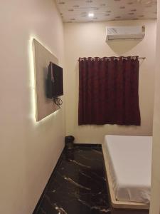 a room with a red curtain and a window at THE UNITED HOTEL in Mumbai