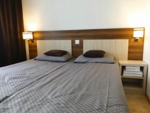 a bedroom with a bed with two pillows on it at ZAJAZD SKRZETUSKI in Wojcieszków