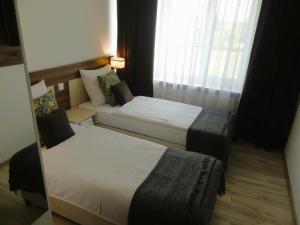 une chambre d'hôtel avec deux lits et un canapé dans l'établissement ZAJAZD SKRZETUSKI, à Wojcieszków