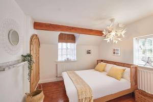 um quarto com uma cama com lençóis brancos e um lustre em Abbey View Cottage em Whitby