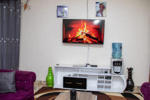 a living room with a fireplace and a tv on the wall at Denverwing Homes in Eldoret