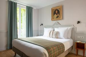 Un dormitorio con una cama grande y una ventana en Hôtel De La Porte Dorée, en París