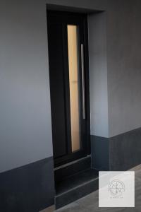 una puerta negra en el lateral de un edificio en Apartmán Kompas, en Spišské Podhradie