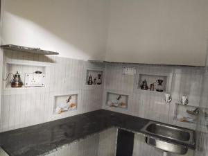 a kitchen with a sink and a counter top at राम जानकी भवन होम स्टे in Faizābād