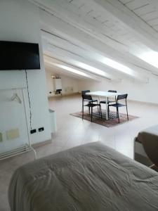 Habitación blanca con mesa y sillas. en Alloggio VR est via Belfiore, en Lavagno