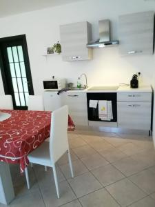 cocina con mesa y cocina con armarios blancos en Alloggio VR est via Belfiore, en Lavagno