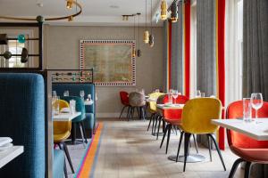 a restaurant with red and yellow chairs and tables at Rudding Park in Harrogate