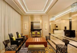 班加罗尔DoubleTree Suites by Hilton Bengaluru Outer Ring Road的带桌椅的客厅