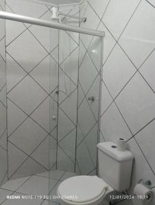 a bathroom with a toilet and a glass shower at Pousada Brisamar Morro dos Conventos in Conventos