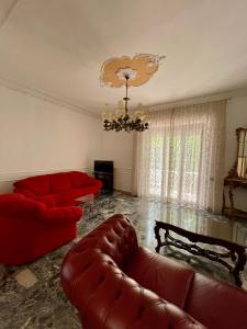 ein Wohnzimmer mit roten Möbeln und einem Kronleuchter in der Unterkunft Casa Zaccardi in Vasto