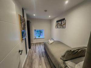Habitación pequeña con cama y ventana en Orange Rentals-Pets Welcome at the Gold Suite, Sleeps 3, High spec, en Liverpool